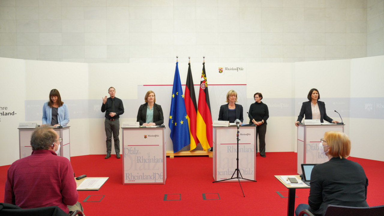 Gruppenbild Schmitt, Binz und Ahnen am Rednerpult